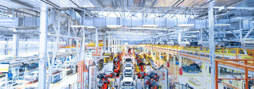 Automobilproduktion mit Montagelinien, Industrierobotern und Fahrzeugen in einer großen Werkhalle.